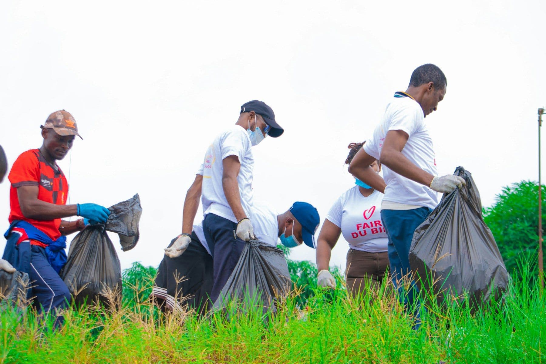 Volunteers in gloves collecting litter at a neighborhood cleanup